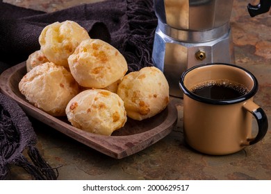 table with delicious cheese breads, a coffee mug and a traditional coffee maker