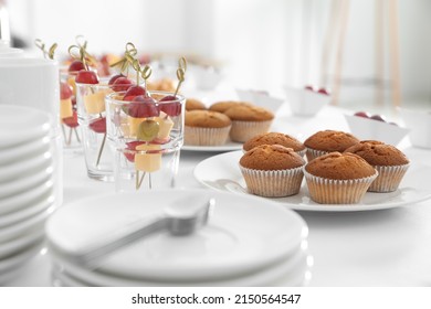 Table with different delicious snacks and dishware indoors. Coffee break - Shutterstock ID 2150564547