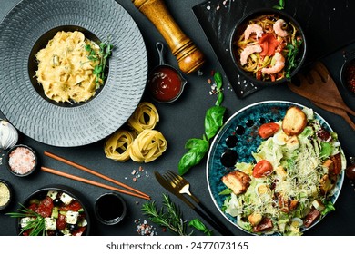 The table is filled with dishes and food. A set of salads, pasta and snacks. Food background.