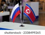 Table flags of the Russian Federation and North Korea together at some event or fair. Flags of the two countries as a symbol of cooperation between states. Joint business of North Korea and Russia