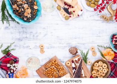 Table With Food And Snacks For The Christmas Party. Table On Top. Italian Traditional Sweets With Nuts And Nougat And Dried Fruit. Black Pasta With Seafood. Free Space For A Copy Of The Text. Greeting