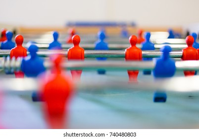 Table football, foosbal red and blue players in macro view. Low angle detailed view with selective focus and shallow depth of field.