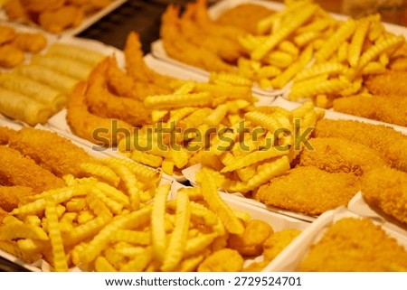 A table full of different types of fried food including french fries, chicken wings, and shrimp