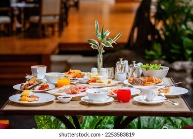 Table full of various fresh food in luxury modern restaurant in hotel. Delicious dishes, including fruits, pastries, and cooked meals on table. Restaurant setting. Breakfast or morning meal - Powered by Shutterstock