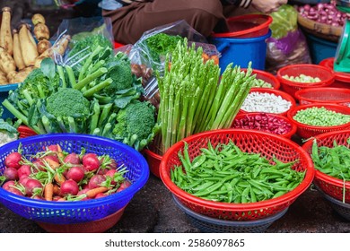 Table full of vegetables including broccoli, asparagus, and potatoes. There are several bowls of vegetables on the table