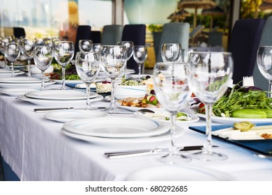 the table is laid for celebration, there are glasses and salad and snack, toned