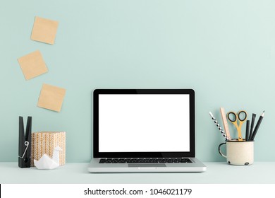 Table with Laptop macbook and stationery on a mint green background. Mock up.