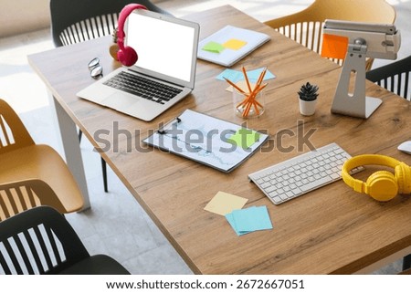 Table with laptop and sticky notes prepared for business meeting in conference hall