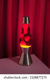 Table lava lamp with changing dynamic traceries. Red textile background. Image of youth and romantic passionate feelings. - Shutterstock ID 2108877275