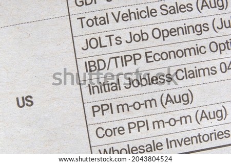 A table listing expected release of various government reports on the US economy. A newspaper listing upcoming US economic reports for business and investment community. Macro closeup view.