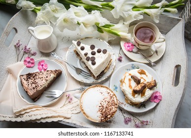 Table with loads of coffee, cakes, cupcakes, desserts, fruits, flowers and croissants. Ancient spoons and a tray, a table in a vintage style. - Powered by Shutterstock