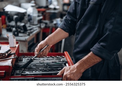 Table with many of tools. Close up view of mechanic in car service station.