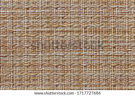 The table mat is brown, woven from thin plastic rods.