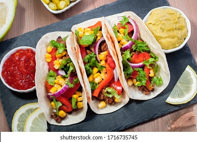 Table With Meat Tacos, Nachos With Sauce, Guacamole, Cinco De Mayo Celebration Party. Appetizers And Traditional Mexican Dishes For Family Dinner On Wooden Table Top, Copy Space