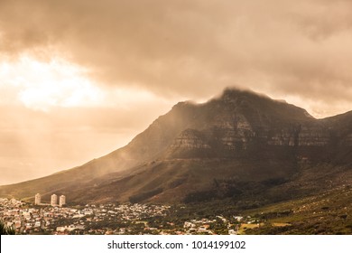 Table Mountain edge at sunset on a cloudy day in Cape Town, South Africa.