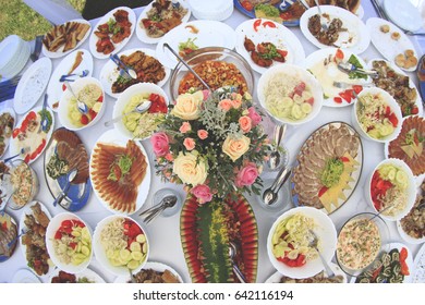 Table With Too Much  Food And Flower In The Middle 