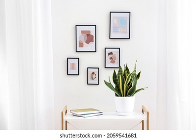 Table near wall with beautiful pictures