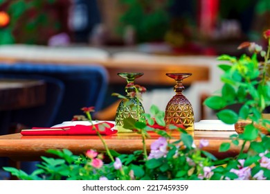 The Table In The Outdoor Restaurant With Dishes And Utensils Is Ready For Serving