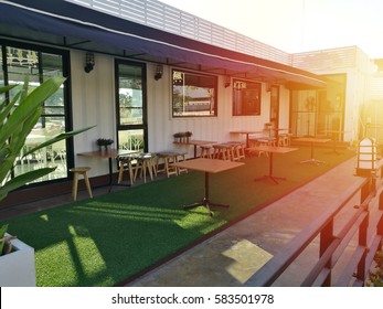 Table outside the restaurant on artificial green grass background