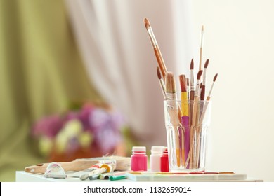Table with paints and tools in artist's workshop