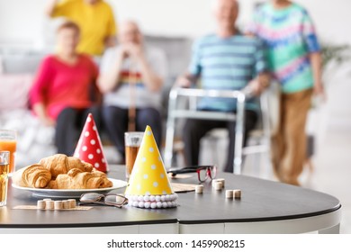 Table With Party Decor And Bingo Game On Table In Nursing Home