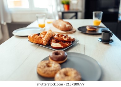 A Table With Pastry, Orange Juice And Coffee Set Up For Breakfast At Home