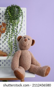 Table With Pegboard And Teddy Bear Near Lilac Wall