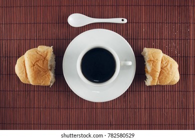 Table ready for breakfast with coffee and a jam croissant