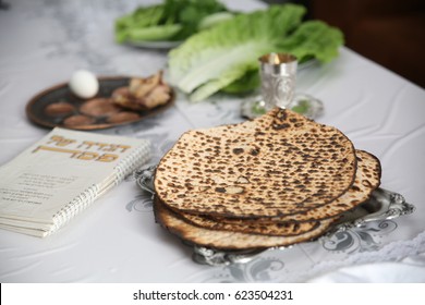 Table Ready For Traditional Seder Ritual during the Jewish holiday of Passover.
. (Kiddush cup, haggada, matzos, lettuce, an arm)