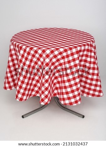 A table with a red checkered tablecloth on a white isolated background