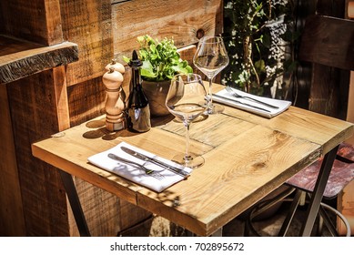 Table in the restaurant in the open air with glasses of wine and serving.