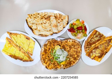 Table scene of assorted take out or delivery foods. Pizza, hamburgers, Doner, fried chicken and sides. Top down view on a table.