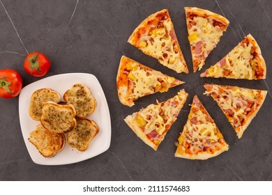 Table Served With Crispy Garlic Bread With Oregano, Sliced Pizza With Cheese, Pineapple And Ham, Starter And Main Course, Studio