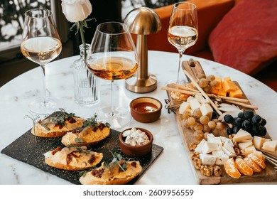 A table served for a dinner with different kinds of appetizers and wine in a bar or restaurant.