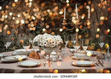 Table Served For Luxury Dinner Party Lighted With Garlands