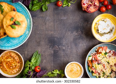 Table Served With Middle Eastern Traditional Vegetarian Dishes. Hummus, Tahini, Pitta, Couscous Salad And Buttermilk Dip With Olive Oil. Dinner Party