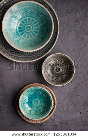 Table set with different size eastern style plates on concrete background with copy space