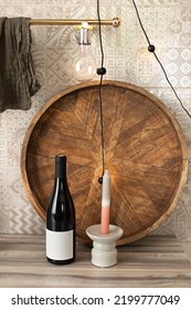 Table set for an event, party, date or wedding with Bottle wine, wooden tray and candles on kitchen counter. Beautiful evening, romance, lovers' day, red wine and candle on the table. 