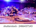 Table set for an event party or wedding reception. round served table banquet ready for guests, round decorated table with empty plate, glasses, forks, napkin. Elegant dinner table. luxurious banquet
