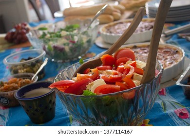 A Table Set For A House Party With Snacks And Salads