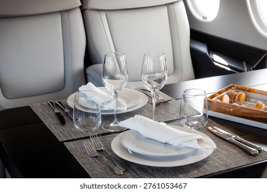 A table set for in-flight dining inside a modern executive business jet, highlighting a luxurious private aviation cabin interior.