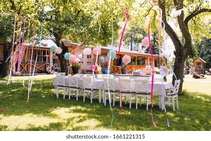 A Table Set For Kids Birthday Party Outdoors In Garden In Summer.