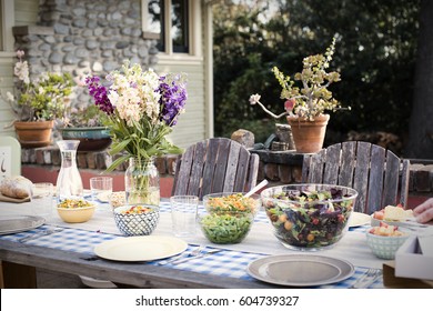 A Table Set For A Meal Outdoors In A Garden