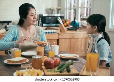 Table Set For Tasty Family Breakfast With Toast Butter Peanut Jam. Happy Sweet Mom And Kid Sitting At Morning Health Meal At Home Kitchen. Little Girl Before Go Elementary School Eat Delicious Meal