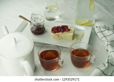 Table set up for tea with crackers and jam.
