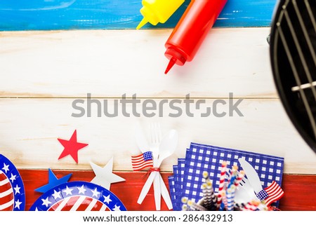 Table set with white, blue and red decorations for July 4th barbecue.