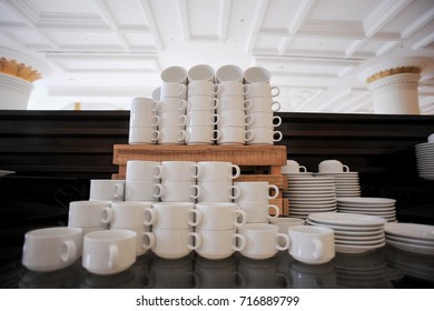 table set up with a lot of white tea or coffee cup at the hotel