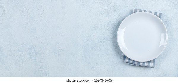 Table Setting Background. Light plate on blue stone table with blue checked tablecloth. Place for text, copy space. Top view, flat lay. Mockup. Banner for website - Powered by Shutterstock