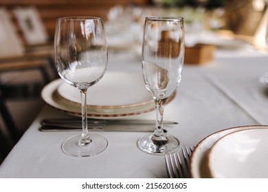 Table Setting, Beautiful White Plates, Silver Cutlery And Crystal Glasses. Outdoor Feast On Holiday. Party