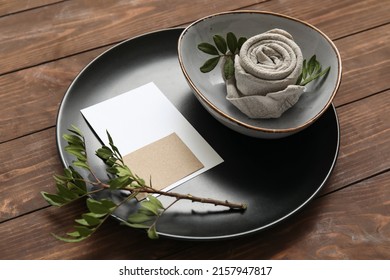 Table setting with blank card and tree branch on wooden background